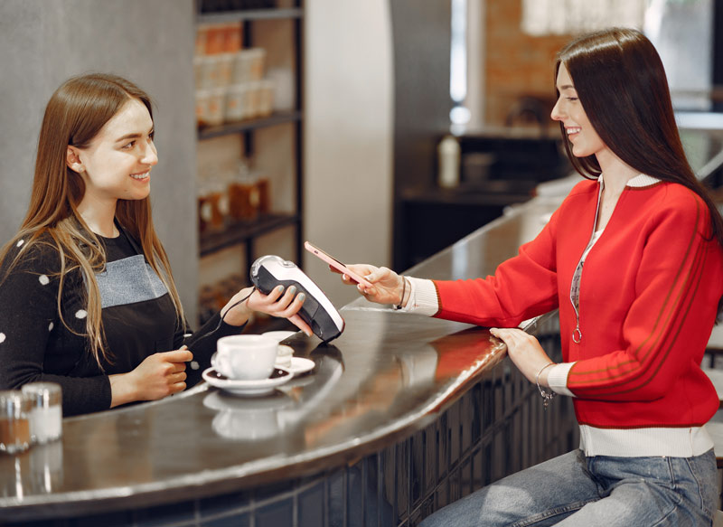 A customer in a coffee shop is completing her payment via OnePay Point of sale