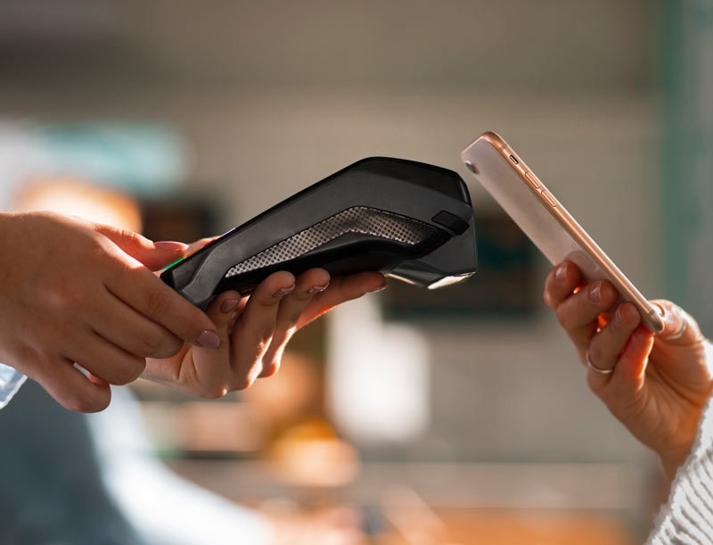 Please rephrase the following sentence: "The image depicts a payment transaction taking place at a Point of Sale (POS) system."